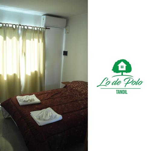 een slaapkamer met een bed met twee handdoeken erop bij Lo de Polo Casa de Descanso in Tandil