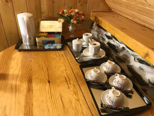 dos bandejas con tazas de té y tazas en un mostrador en Les Tilleuls, en Le Bourg-dʼOisans