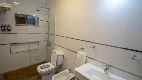 a white bathroom with a toilet and a sink at Salta Suite in Salta