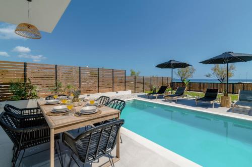 a patio with a table and chairs next to a pool at Alas Suites in Alykes