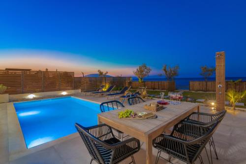 a patio with a table and chairs next to a swimming pool at Alas Suites in Alykes