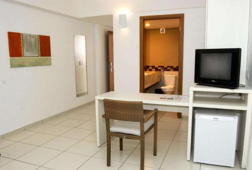 Uma TV ou centro de entretenimento em Best Western Suites Le Jardin Caldas Novas