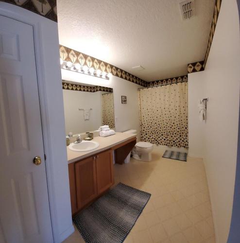 a bathroom with a sink and a toilet at Four-Bedroom Pool Home Kissimmee in Orlando