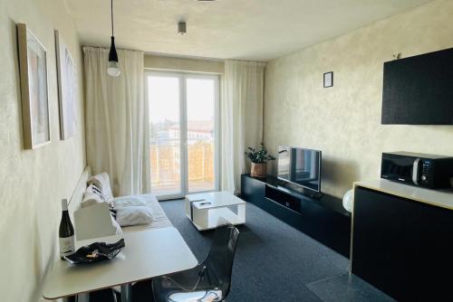Cette petite chambre comprend une table et un four micro-ondes. dans l'établissement Cozy Apartment - CityCentre - FreeParking - SelfCheck-in, à Liptovský Mikuláš
