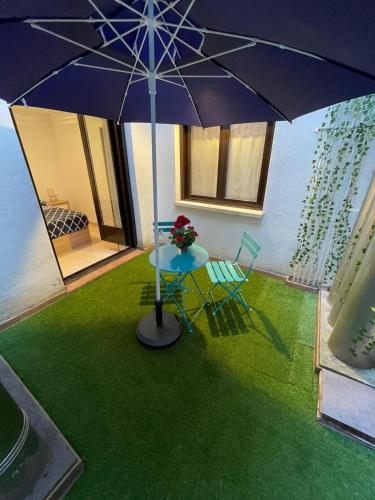 a table and a blue chair and an umbrella at Laurel centro in Logroño