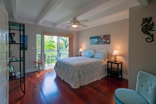 a bedroom with a bed and a window and a chair at Puamana 25B in Princeville
