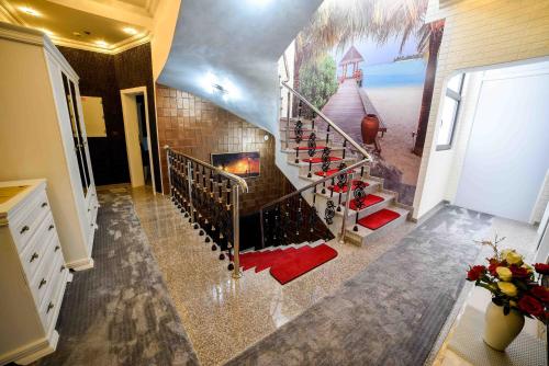 a room with a staircase with a fireplace and a painting at Hotel PALACE in Velika Kladuša