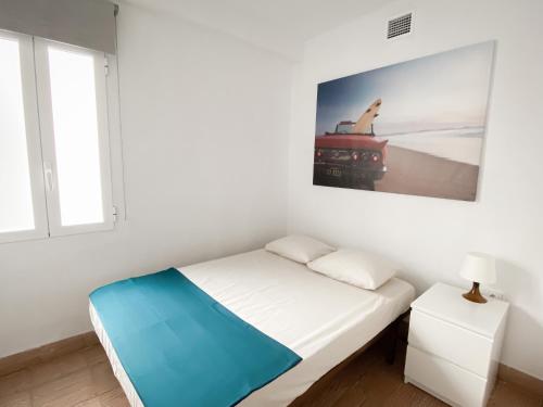 Cette chambre blanche dispose d'un lit et d'une photo murale. dans l'établissement Disfruta de unos días en la playa ¡Y mucho más!, à Burriana