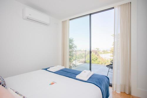 a bedroom with a bed and a large window at Liiiving in Porto - City View Apartments in Porto