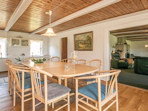 a dining room with a wooden table and chairs at 12 person holiday home in Aabybro in Åbybro