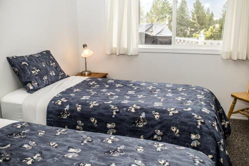 1 dormitorio con 2 camas y ventana en Crescent Motel en Radium Hot Springs