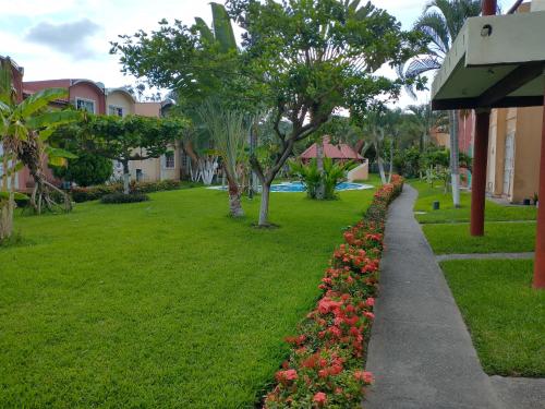 a garden next to a building with flowers at Casa con alberca Ixtapa Zihuatanejo in Ixtapa