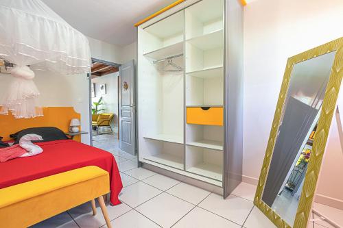 a bedroom with a red bed and a mirror at VILLA DALHIA in Pointe-Noire