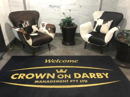 two chairs and a welcome rug with a crown on dairy sign at Crown on Darby Newcastle in Newcastle