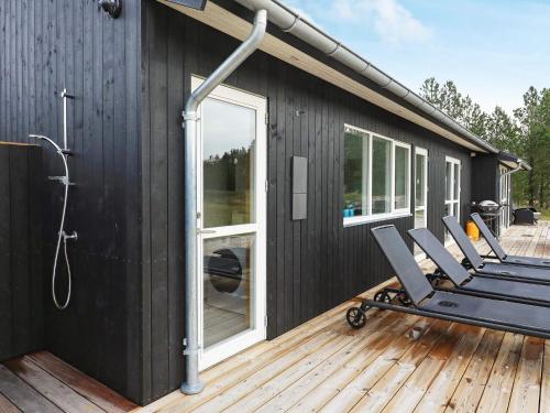 a deck with chairs and a shower on a house at 8 person holiday home in Jerup in Jerup