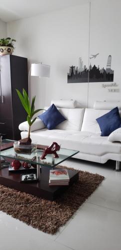 ein Wohnzimmer mit einem weißen Sofa und einem Couchtisch in der Unterkunft Edificio Vertika in Cali