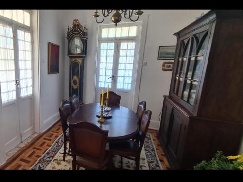 uma sala de jantar com uma mesa e um relógio avô em Casa do Jardim (Garden House) em Vila do Conde
