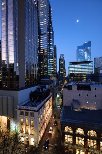 a city skyline at night with tall buildings at Flinders Landing Apartments in Melbourne