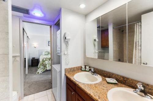 baño con 2 lavabos y espejo grande en Waikiki Beach Condominiums, en Honolulu