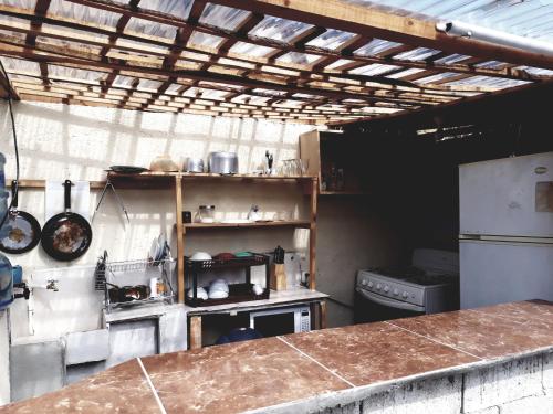 a kitchen with a counter top and a refrigerator at Hotel Ideal, Your House in Quetzaltenango in Quetzaltenango