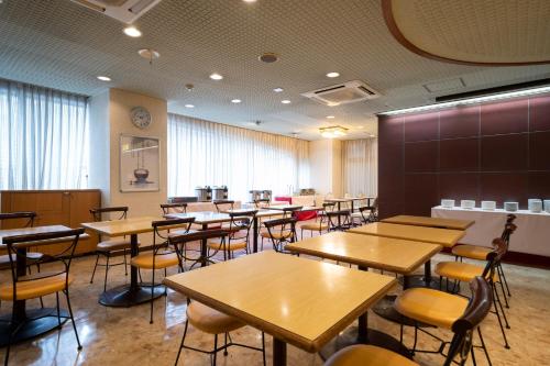 a classroom with tables and chairs in a room at Smile Hotel Nabari in Nabari