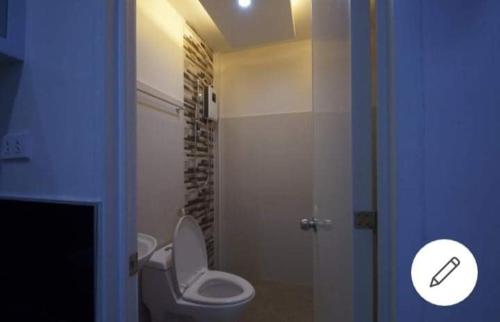 a bathroom with a toilet and a glass shower at Sea Garden Suites in Dauis