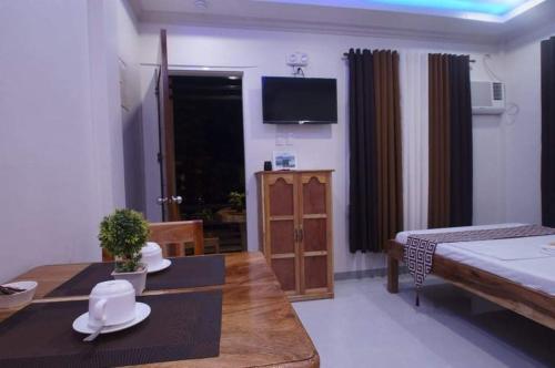 a living room with a bed and a dining table at Sea Garden Suites in Dauis