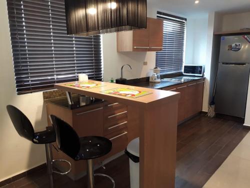 a kitchen with a island with two bar stools at Playa Blanca Panama in Río Hato
