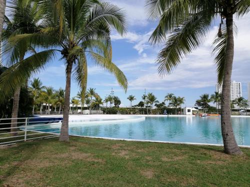 a swimming pool with palm trees in a resort at Playa Blanca Panama in Río Hato