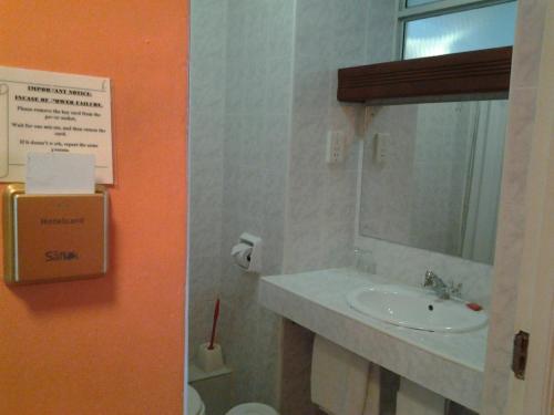 モンバサにあるMidview Hotel Nyaliのバスルーム(洗面台、鏡付)