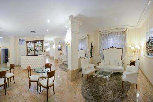 a living room with white furniture and a table and chairs at Zanhotel Tre Vecchi in Bologna