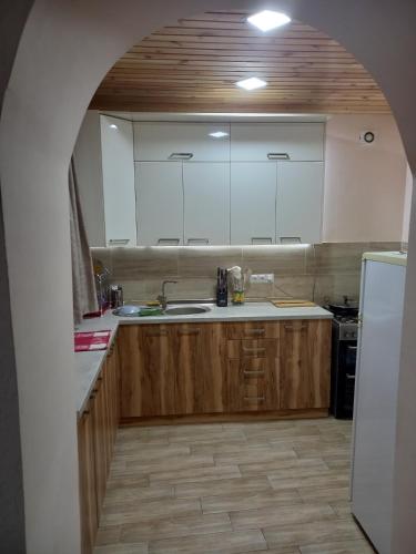 a kitchen with wooden cabinets and a white refrigerator at Spardishi tower in Mestia