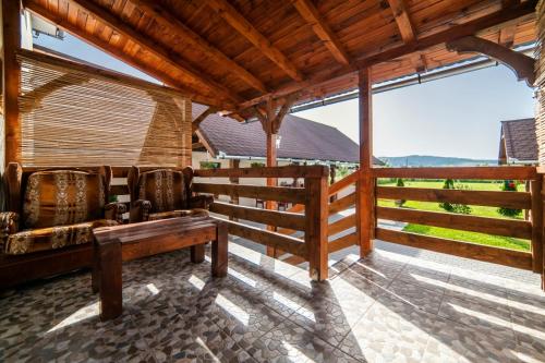 a porch with a bench and a fence at Absolut Residence Hateg in Haţeg