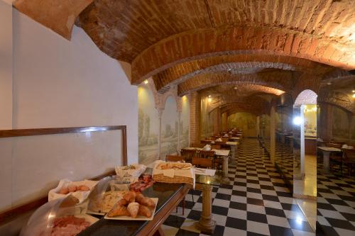 un restaurante con una larga fila de mesas con comida en Zanhotel Tre Vecchi en Bolonia