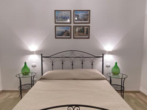 una camera con un letto e due tavoli con vasi verdi di Donna Filomena a Monopoli