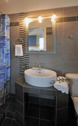 a bathroom with a sink and a mirror at Elea Apartments in Kálamos Kythira