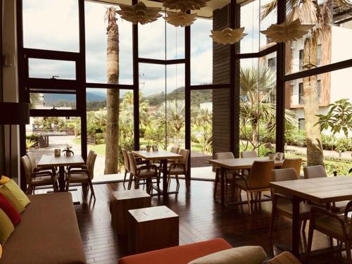 a restaurant with tables and chairs and large windows at Aqua Star Villa Homestay in Dongshan