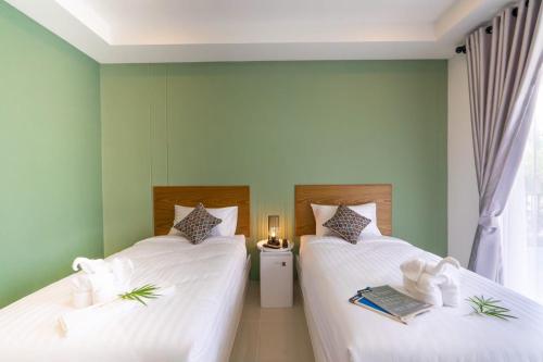 2 letti in una camera con pareti verdi di น่านวรรณวัตร รีสอร์ท Nan Wannawat Resort a Ban Tong