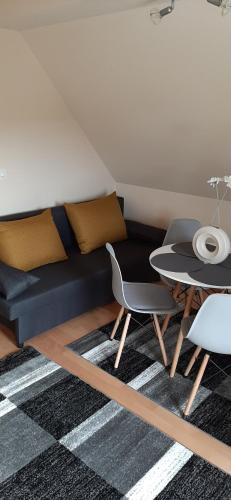 een woonkamer met een bank en een tafel bij NAPKŐ APARTMAN in Sopron