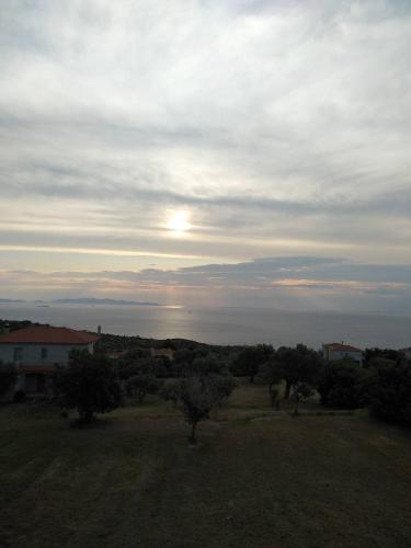 a view of a field with the sunset in the sky at Ellina's Home - Euboea island Greece in Oxílithos