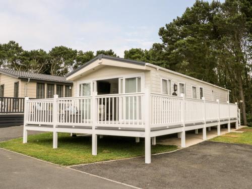 a large white mobile home with a porch at The Rodley Pines in Scarborough