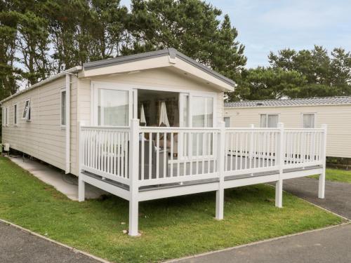 a mobile home with a porch and a white deck at The Rodley Pines in Scarborough
