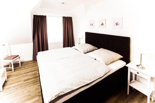 een slaapkamer met een groot bed met een zwart hoofdeinde bij Gästehaus Sam in Bad Sassendorf