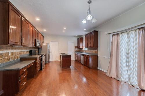 a large kitchen with wooden cabinets and a large window at Incredibly Spacious Carmel Home with Fully Equipped Kitchen - 4700 Sq Ft! Sleeps 15! Pet Friendly! home in Carmel