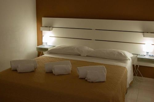 a bedroom with a large bed with two white pillows at Le Zagare in Lascari