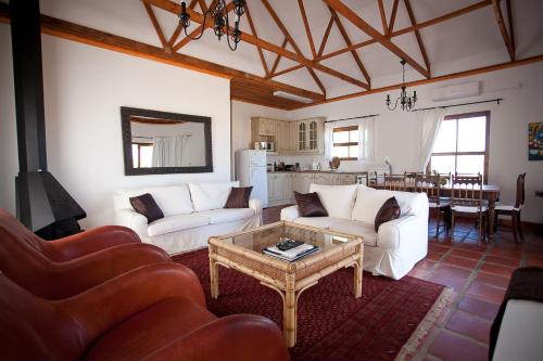 a living room with two white couches and a table at Eikelaan Farm Cottages in Tulbagh