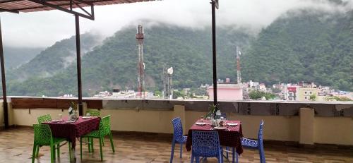 a restaurant with tables and chairs with a view of a mountain at Hotel The Shivaay - Delight Inn Rishikesh in Rishīkesh
