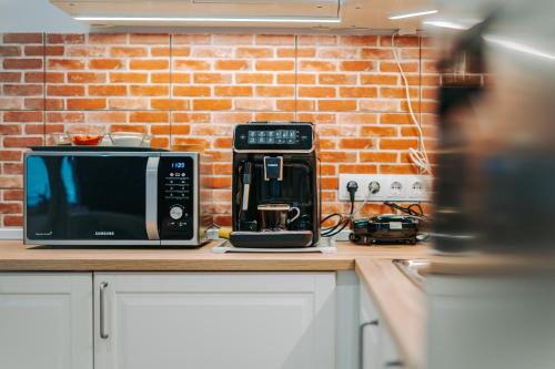 a kitchen counter with a microwave and a coffee maker at Kali Host Home Away From Home in Târgu-Mureş