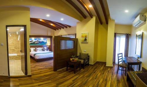 a room with a bedroom with a bed and a table at Himalaya Drishya Resort in Dhulikhel