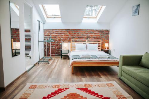 a bedroom with a bed and a green couch at Kali Host Home Away From Home in Târgu-Mureş